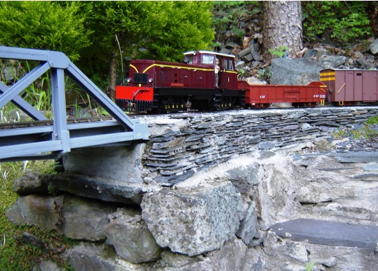 Castell Caernarfon, B Wagon and V16 Brake Van rumble up from the short tunnel onto Brynyfelin Bridge. The familiar looking driver seems to be pondering upon his lot or maybe he is concerned that the bridge may not take the weight.